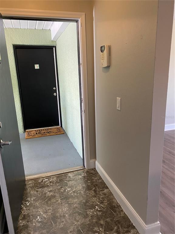 An entryway with marble-look flooring leads to an exterior door with a welcome mat — 4252 PERSHING POINT UNIT 4, ORLANDO, FL