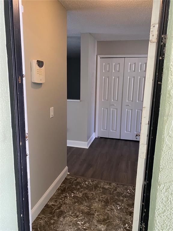 A view through a doorway into an entryway with marble-style flooring and a closet — 4252 PERSHING POINT UNIT 4, ORLANDO, FL
