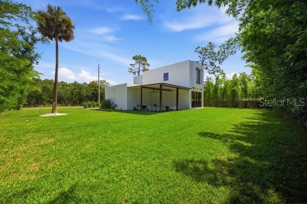A modern kitchen features a black and white marble island, dark stools, and white cabinetry — 7412 VAN DYKE ROAD, ODESSA, FL
