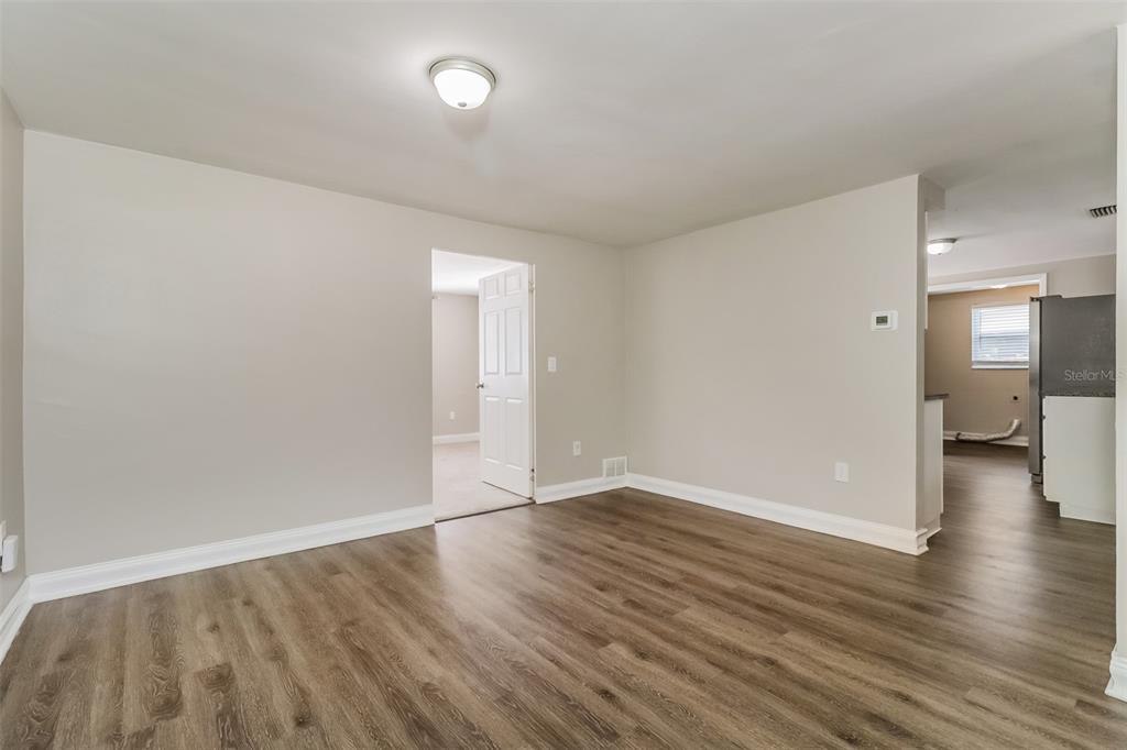 A room with light-colored walls, wood-look flooring, a ceiling light, and a doorway — 7710 VENICE DRIVE, PORT RICHEY, FL