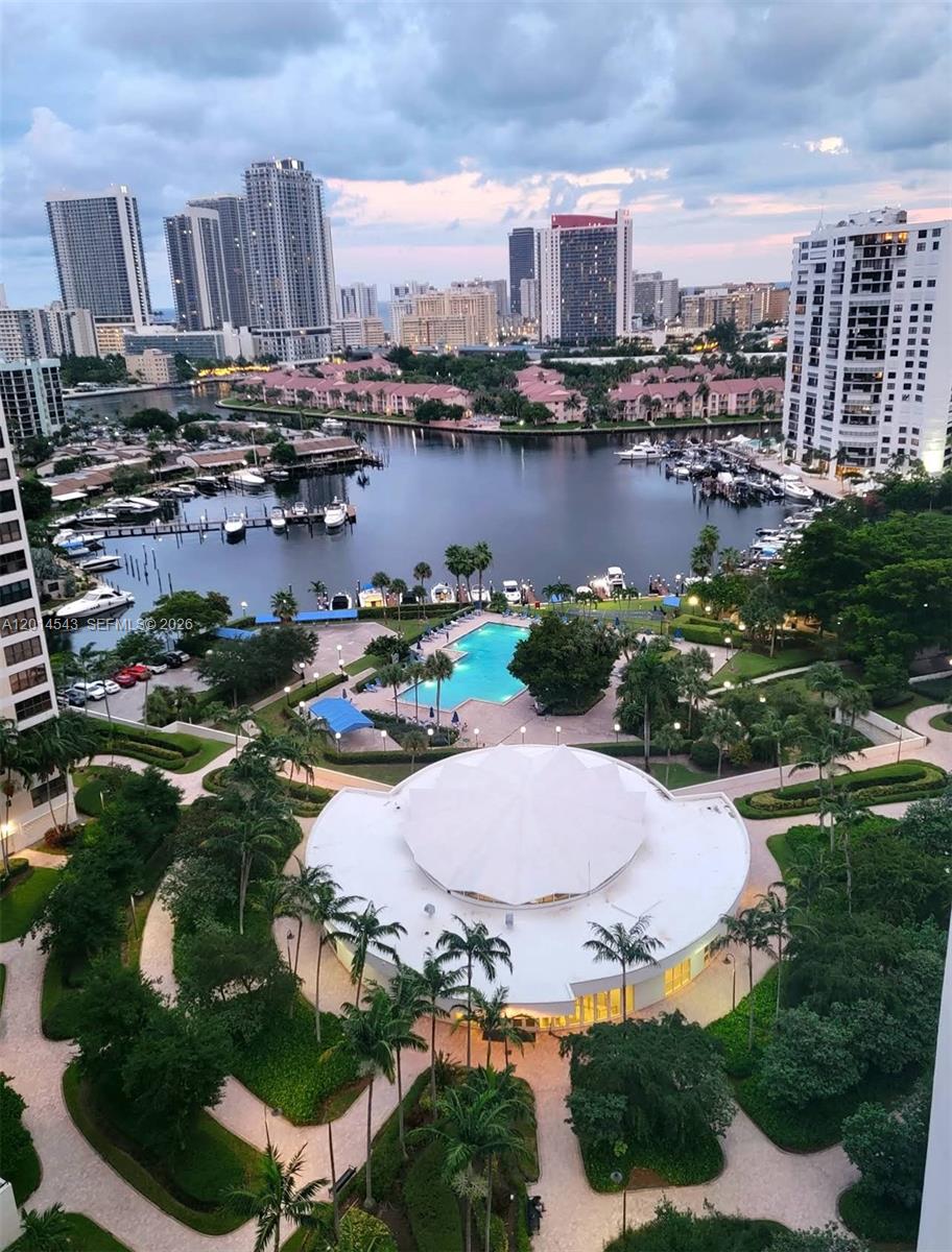 An elevated view of a waterfront residential complex featuring a pool, marina, and city skyline — 600 Three Islands Blvd # 418, Hallandale Beach FL 33009, HALLANDALE BEACH, FL