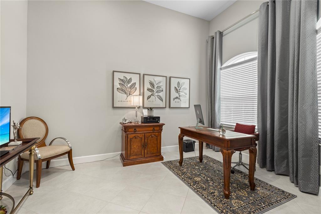 A home office features a wooden desk, a side cabinet, and three framed botanical prints — 4839 SEVILLA SHORES DRIVE, WIMAUMA, FL