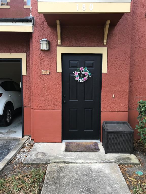 A multi-story apartment building exterior with a red facade and a red location pin — 180 VILLA DI ESTE TERRACE UNIT 212, LAKE MARY, FL