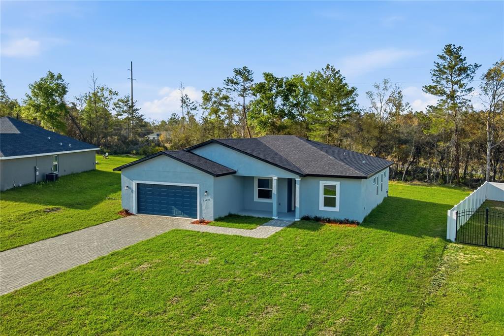 An aerial view of a single-story light blue house with a dark roof and garage — 13695 SW 40TH CIRCLE, OCALA, FL