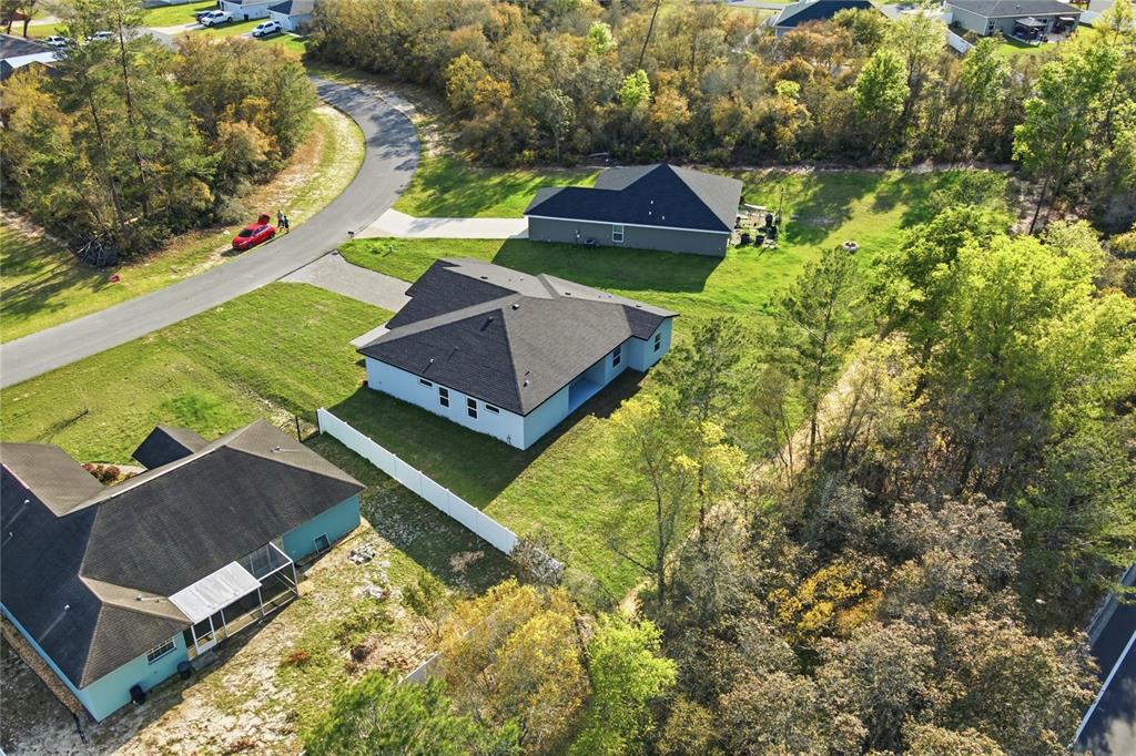 An aerial view shows three suburban houses with dark roofs surrounded by trees and lawns — 13695 SW 40TH CIRCLE, OCALA, FL