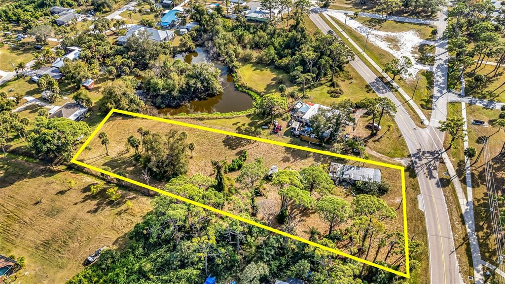 An aerial view shows a rectangular lot outlined in yellow with trees and a structure — 787 OLD ENGLEWOOD ROAD, ENGLEWOOD, FL