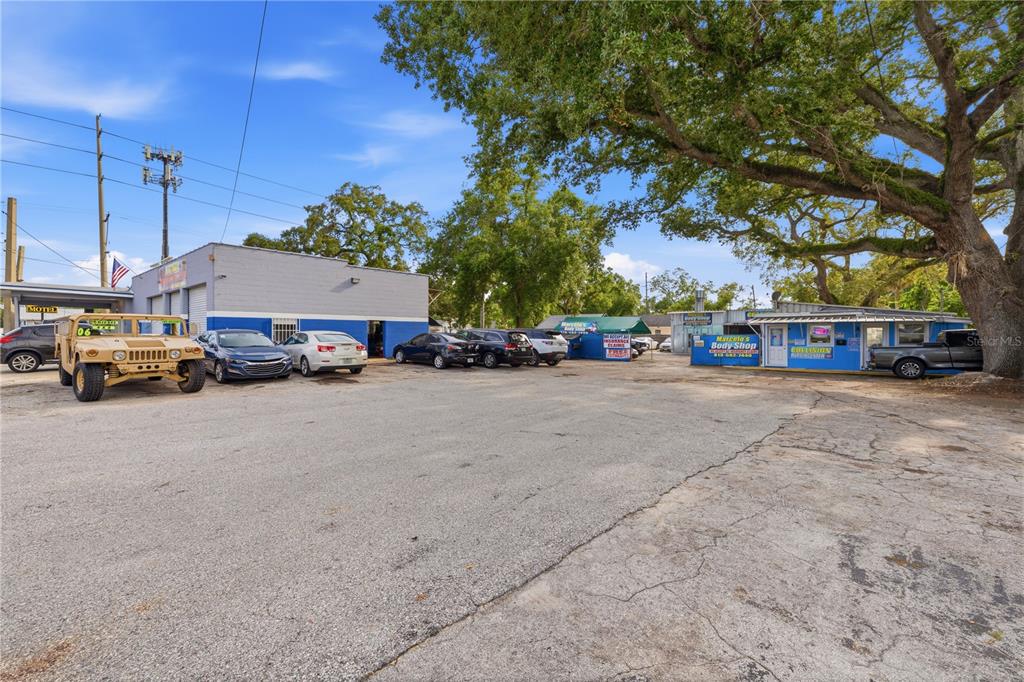 An exterior view of a commercial property with a parking lot and auto body shop — 6200 N NEBRASKA AVENUE, TAMPA, FL