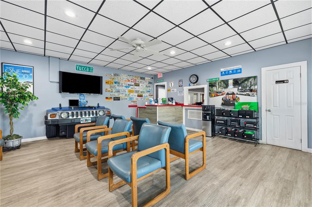 A waiting room features blue chairs, a Hummer-themed desk, and walls decorated with license plates — 6200 N NEBRASKA AVENUE, TAMPA, FL