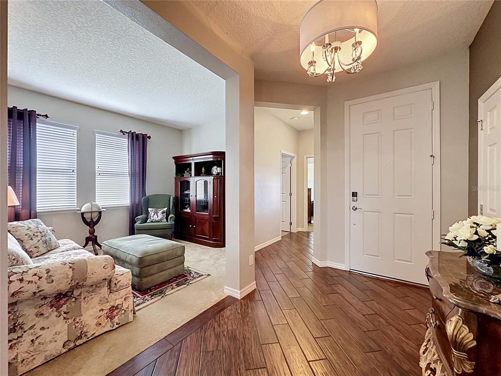 A foyer with wood-look tile flooring leads to a carpeted living area with a hutch — 395 SILVER MAPLE ROAD, GROVELAND, FL