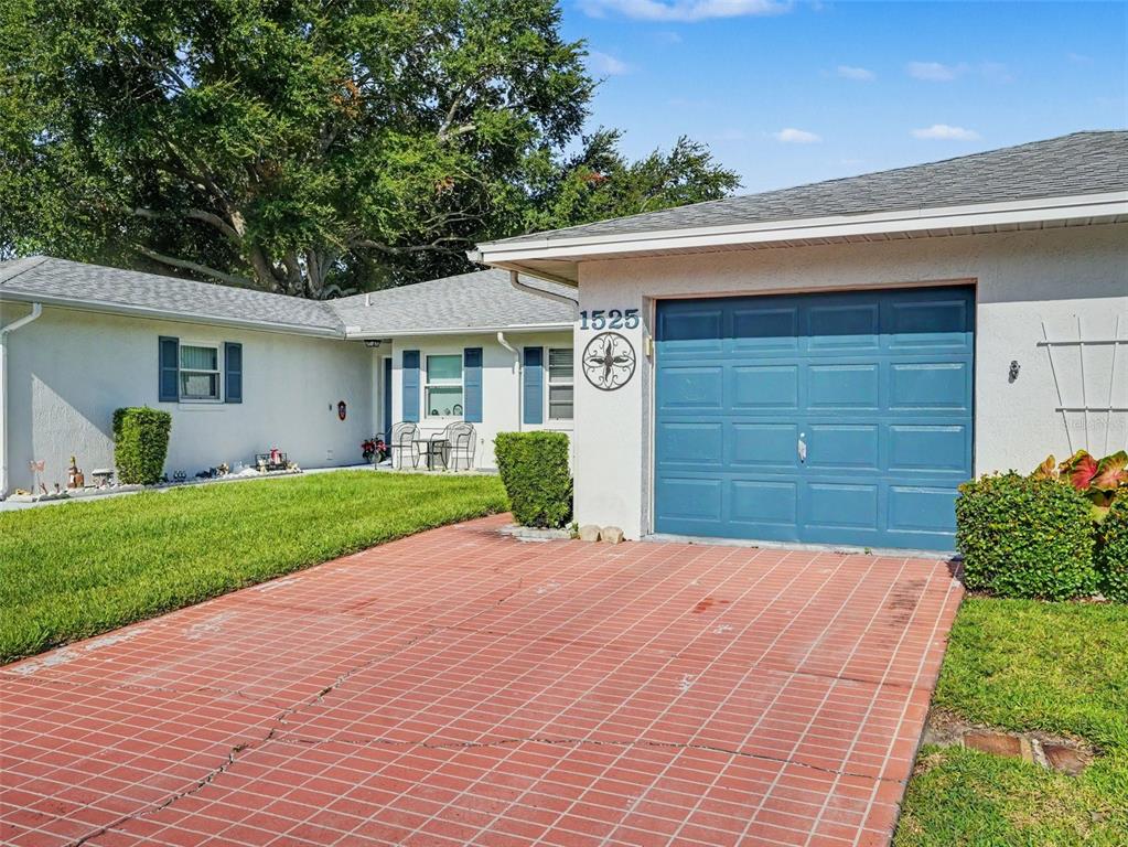 An open living area features wood-look tile flooring, white walls, and two ceiling fans — 1525 OAKVIEW CIRCLE SE, WINTER HAVEN, FL