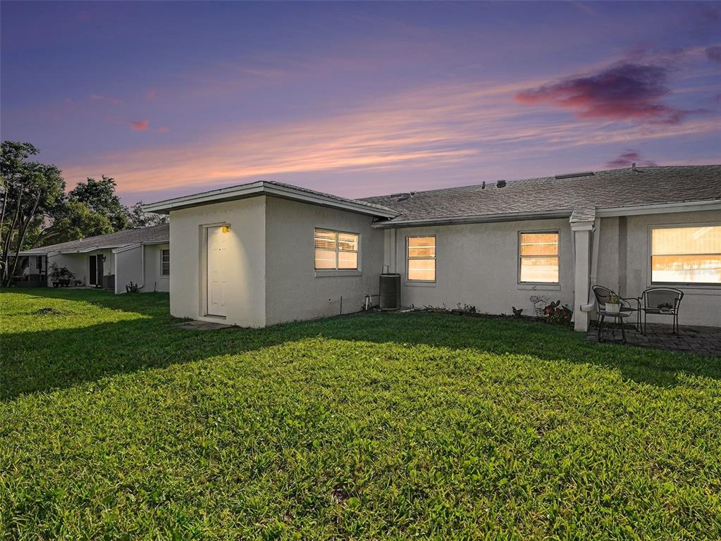 A white kitchen features wood-look flooring, white cabinets, a dishwasher, and a floral wallpaper border — 1525 OAKVIEW CIRCLE SE, WINTER HAVEN, FL