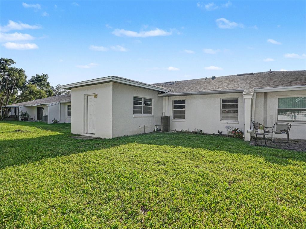 A room with wood-look flooring, a white refrigerator, a ceiling fan, and sliding glass doors — 1525 OAKVIEW CIRCLE SE, WINTER HAVEN, FL