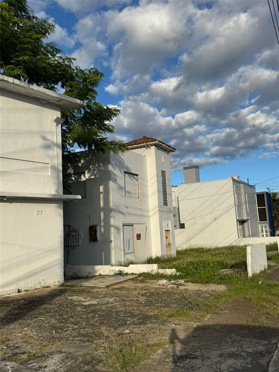A view of the exterior of white multi-story buildings with a grassy lot in front — 39 AVENIDA MAYAGUEZ, SAN JUAN, PR