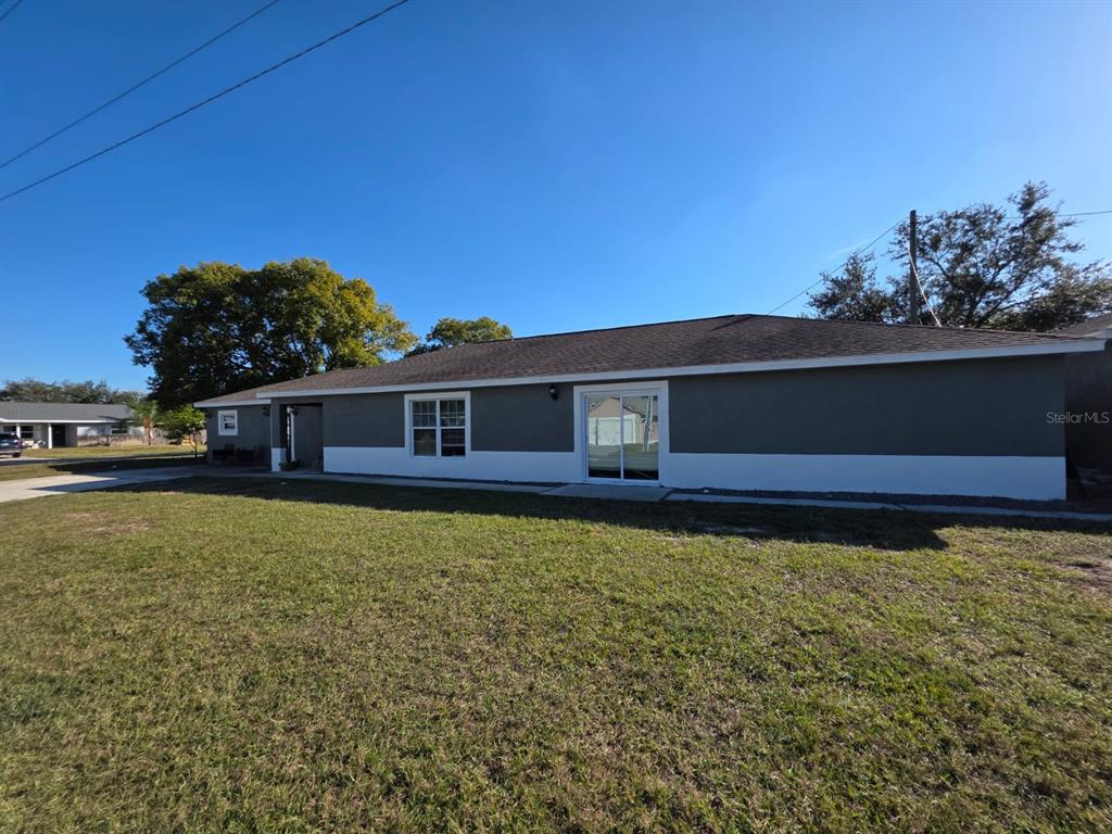 The exterior of a single-story house features gray and white siding with a sliding glass door — 600 GEORGIA AVENUE, ST CLOUD, FL