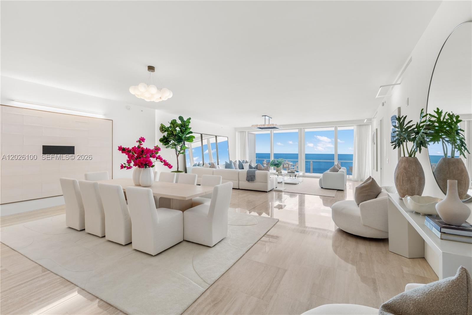 A bright, open-concept living and dining area features white furniture, marble floors, and ocean views — 9001 Collins Ave # 1003, Surfside FL 33154, SURFSIDE, FL