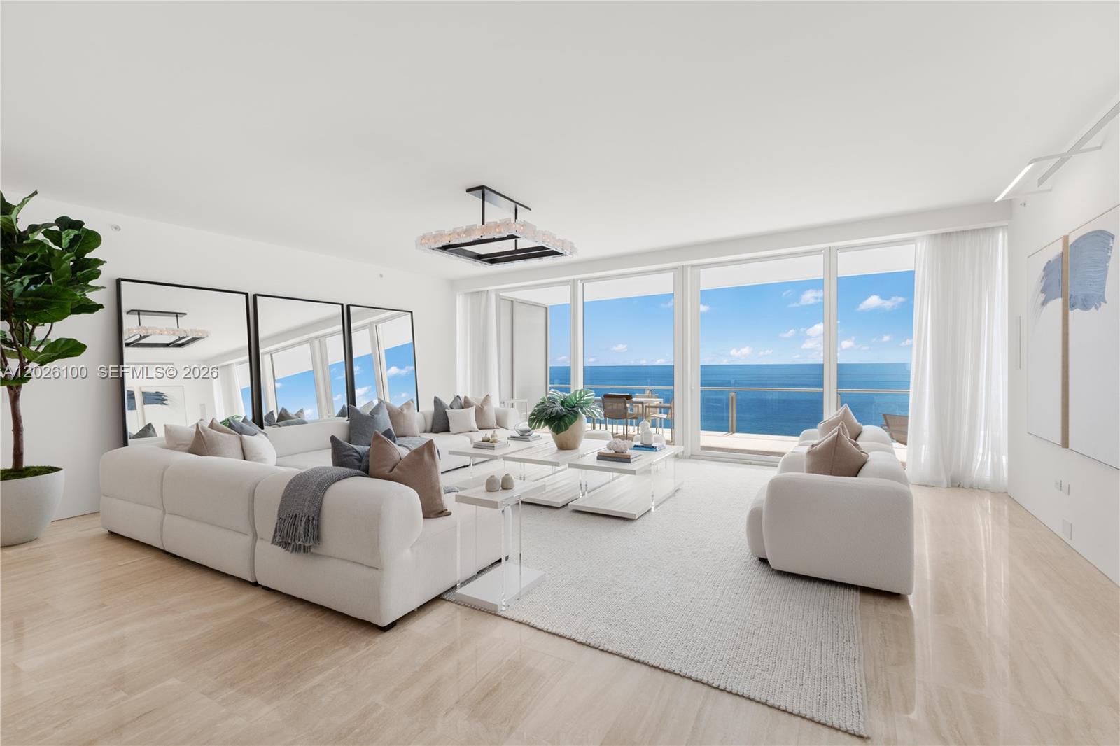 A bright living room features white sofas, a large area rug, and floor-to-ceiling ocean views — 9001 Collins Ave # 1003, Surfside FL 33154, SURFSIDE, FL