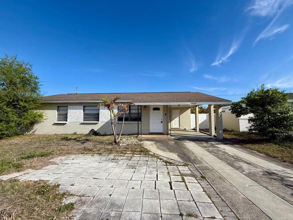 A single-story house with a paved driveway, a carport, and a light-colored exterior — 4109 W WALLACE AVENUE, TAMPA, FL