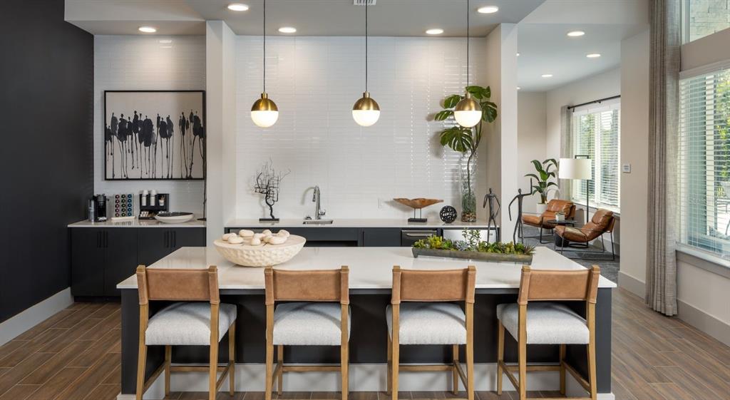 A modern kitchen features a large white island with four chairs and dark cabinetry — 10881 CALADESI AVENUE UNIT A2, TAMPA, FL