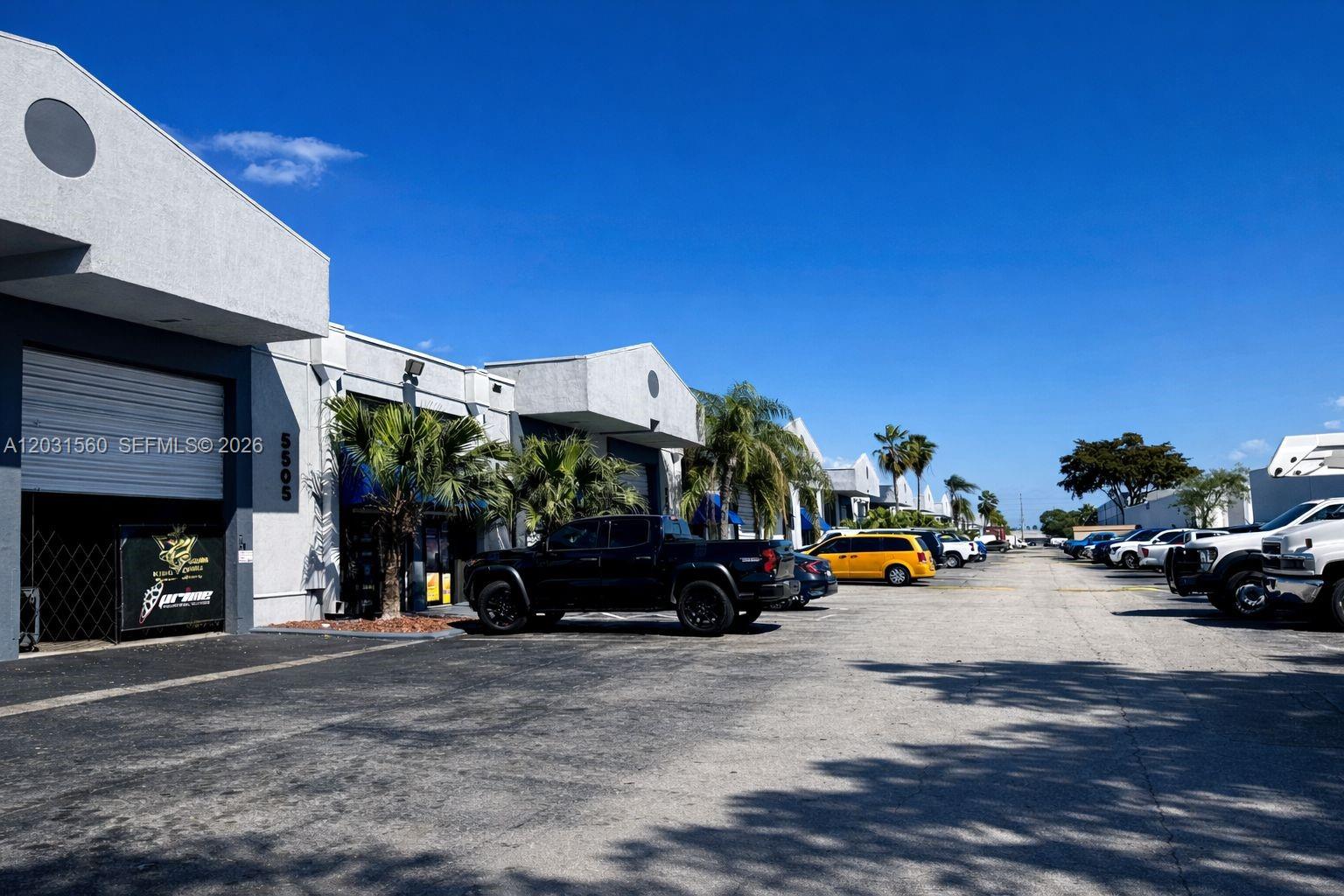 A row of commercial warehouse units with parking spaces in front under a clear sky — 5501 NW 74th Ave # 5501, Miami FL 33166, MIAMI, FL