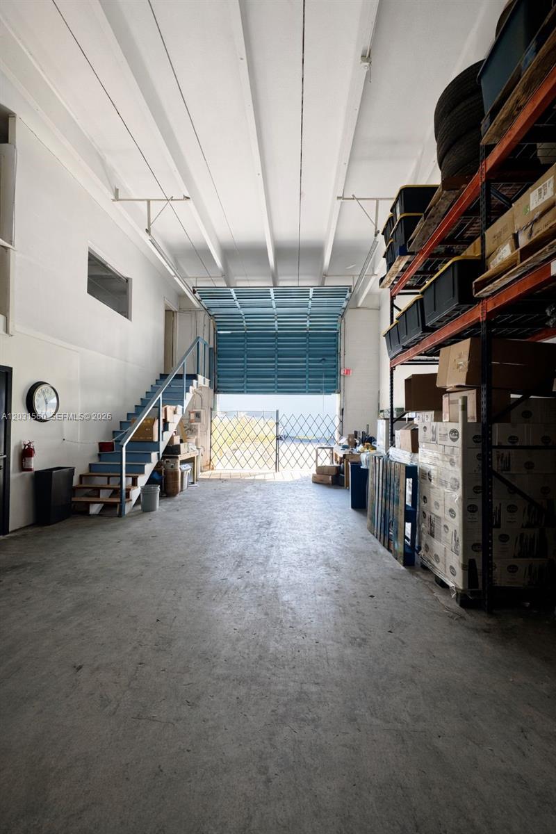 This industrial warehouse space features a concrete floor, metal staircase, and tall pallet racking — 5501 NW 74th Ave # 5501, Miami FL 33166, MIAMI, FL