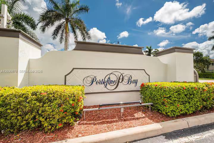 A white stucco entrance sign for Portofino Bay sits behind manicured hedges under a blue sky — 2327 NE 37th Ter, Homestead FL 33033, HOMESTEAD, FL