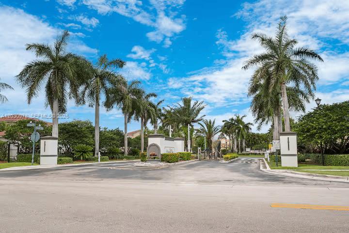 A gated entrance with palm trees and white pillars leads into a residential community — 2327 NE 37th Ter, Homestead FL 33033, HOMESTEAD, FL