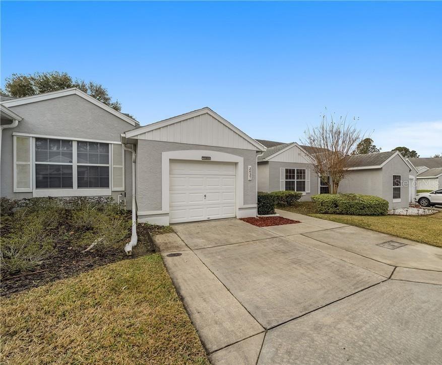 A gray single-story house features a white garage door and a concrete driveway — 2437 SW 20TH COURT, OCALA, FL