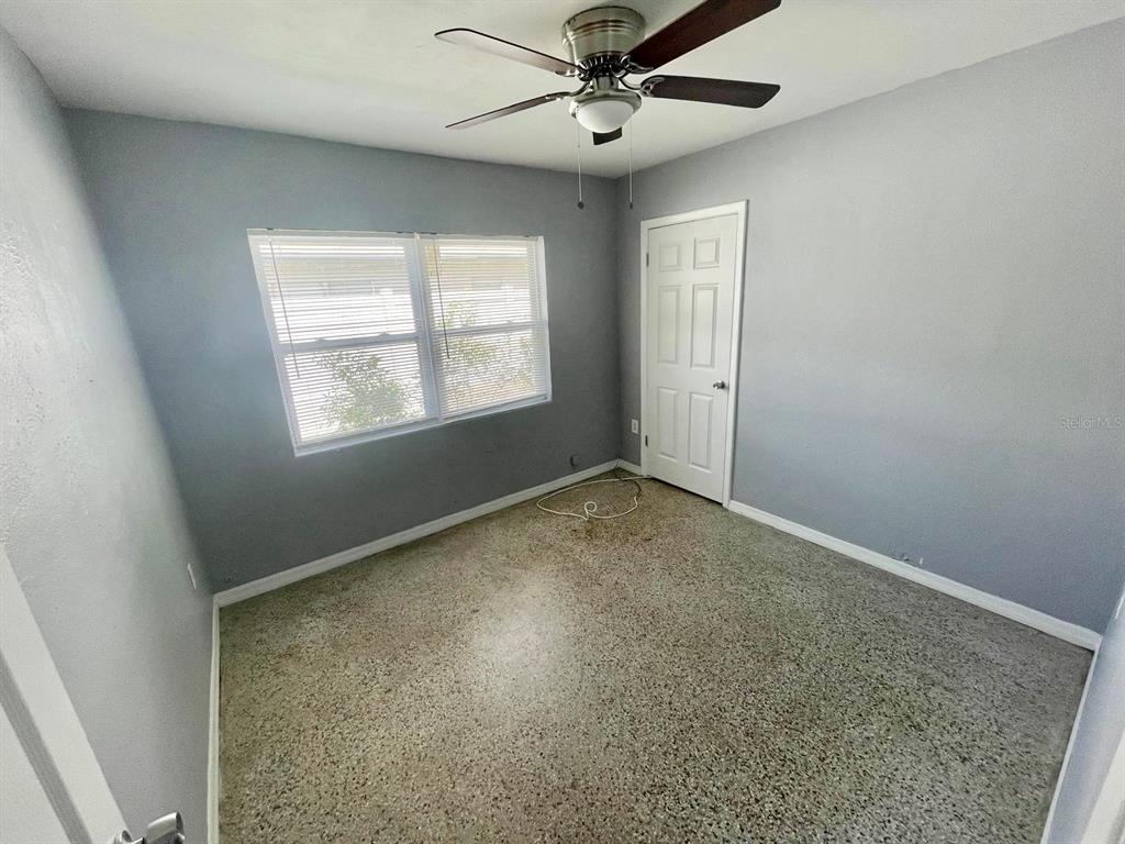 A bedroom with gray walls, a ceiling fan, a window with blinds, and terrazzo flooring — 4615 EDGEWATER DRIVE, ORLANDO, FL