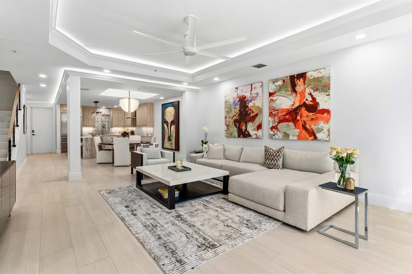 A modern living room features a beige sectional sofa, a coffee table, and abstract wall art — 122 SE 6th Avenue # 3, Delray Beach FL 33483, DELRAY BEACH, FL