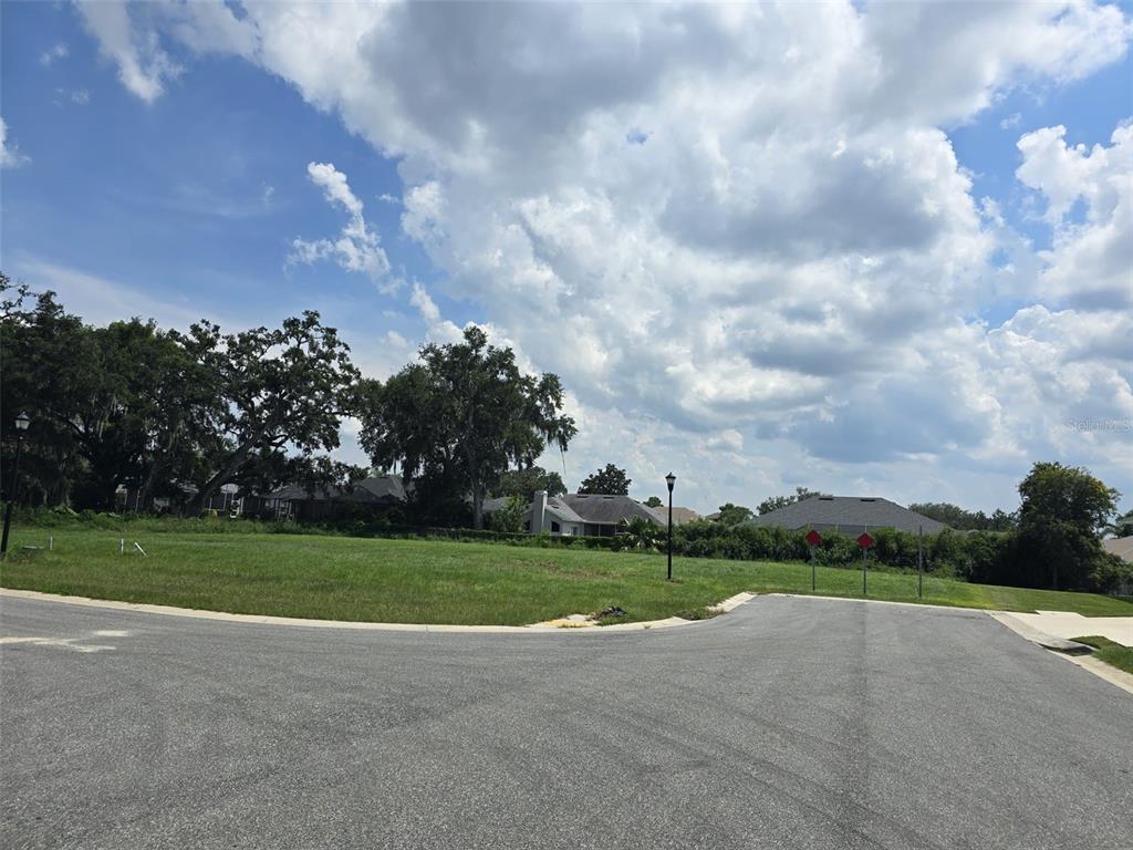 A vacant, grassy residential lot sits at the end of a paved cul-de-sac — 605 ARIA DR., LAKELAND, FL