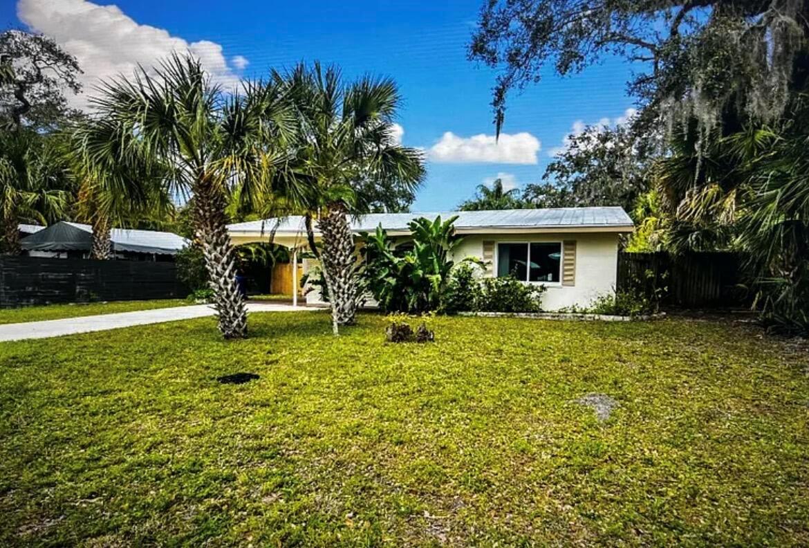 A single-story house with a metal roof, palm trees, and a carport in the yard — 515 Cypress Road, Vero Beach FL 32963, VERO BEACH, FL