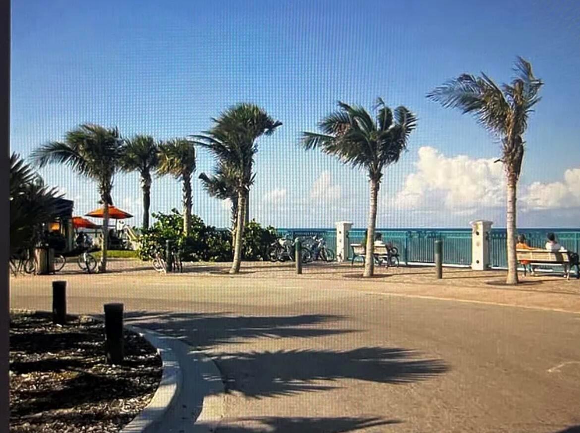 A paved path lined with palm trees leads toward a blue ocean view — 515 Cypress Road, Vero Beach FL 32963, VERO BEACH, FL
