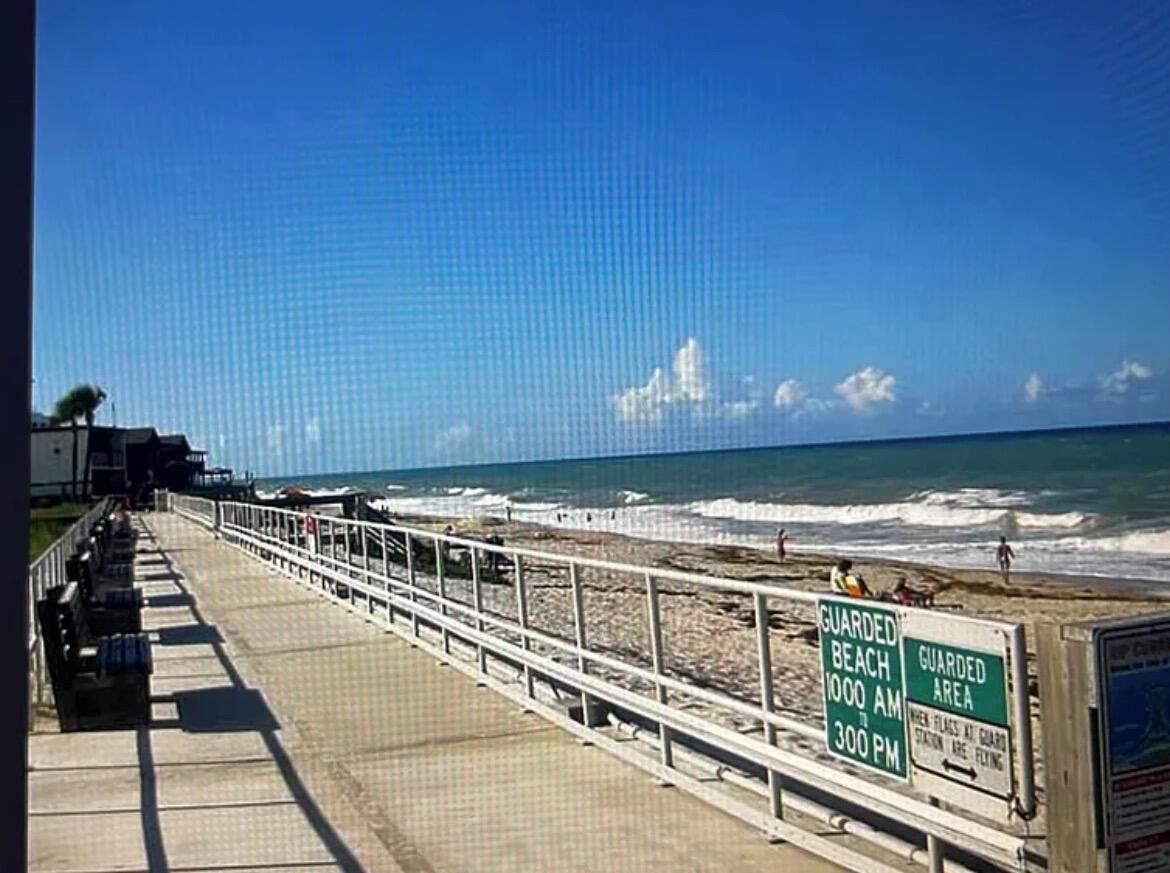 A boardwalk overlooks a sandy beach and the ocean under a clear blue sky — 515 Cypress Road, Vero Beach FL 32963, VERO BEACH, FL