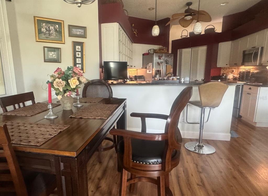 A dining area with a wooden table and chairs sits adjacent to an open kitchen — 4062 WESTBOURNE CIRCLE, SARASOTA, FL