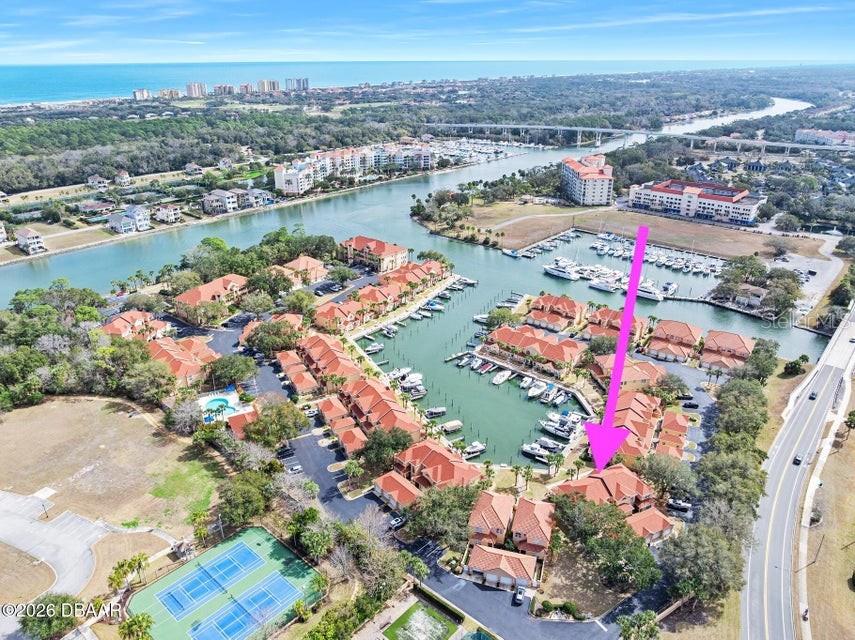 This aerial view shows a waterfront residential complex with a marina and tennis courts — 25 MARINA POINT PLACE, PALM COAST, FL