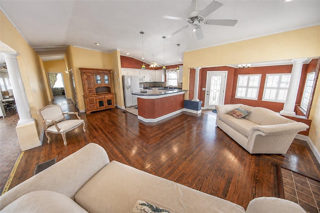 A living room with a fireplace, white sofas, and an open kitchen with ocean views — 3873 S ATLANTIC AVENUE, DAYTONA BEACH SHORES, FL