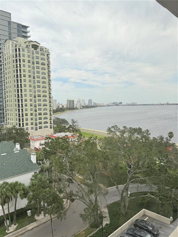 An elevated view shows a waterfront landscape with a tall apartment building and distant city skyline — 3301 BAYSHORE BOULEVARD UNIT 1001E, TAMPA, FL