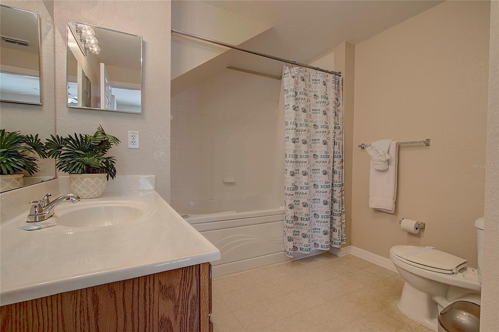 A bathroom features a vanity with a sink, a toilet, and a shower-tub combination — 4003 SAN SABASTIAN DRIVE UNIT 106, KISSIMMEE, FL