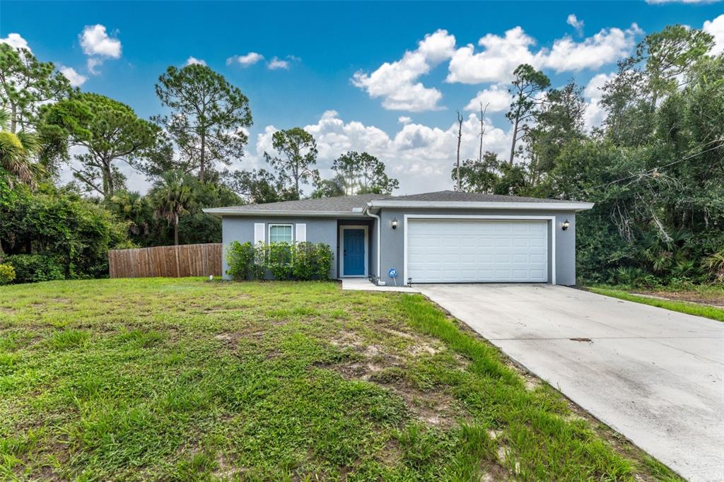 A gray single-story house with a blue front door and a two-car garage — 18346 SAGAMORE AVENUE, PORT CHARLOTTE, FL