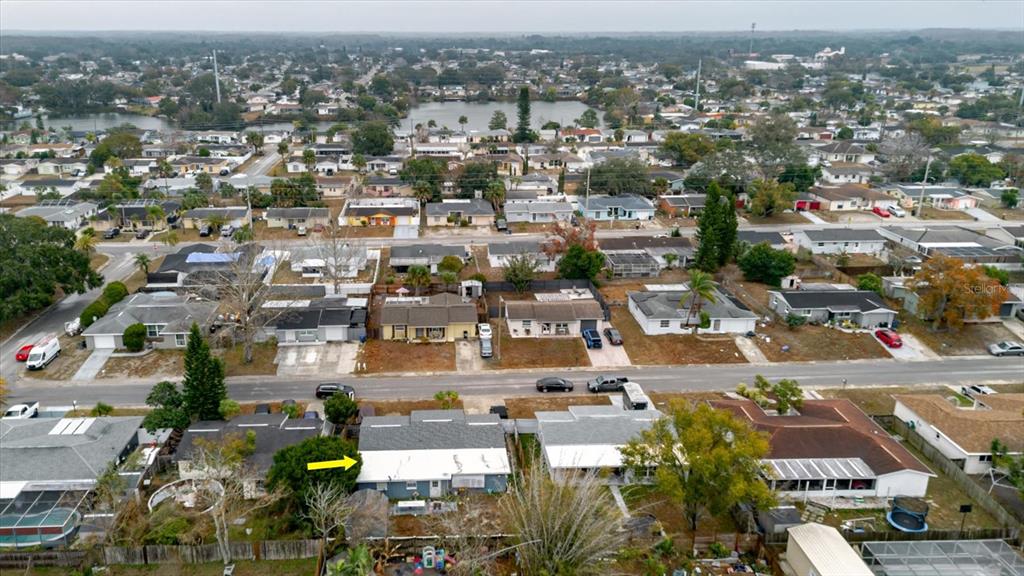 An aerial view shows a residential neighborhood with single-story houses and a yellow arrow pointing down — 9731 RAINBOW LANE, PORT RICHEY, FL