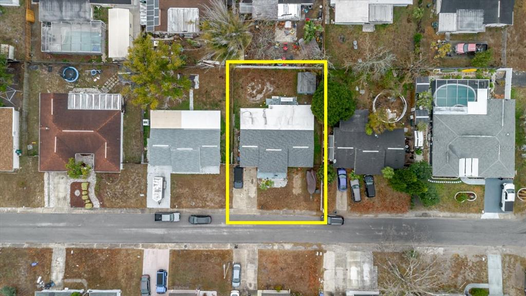 This aerial view shows a residential property with a house and backyard outlined in yellow — 9731 RAINBOW LANE, PORT RICHEY, FL