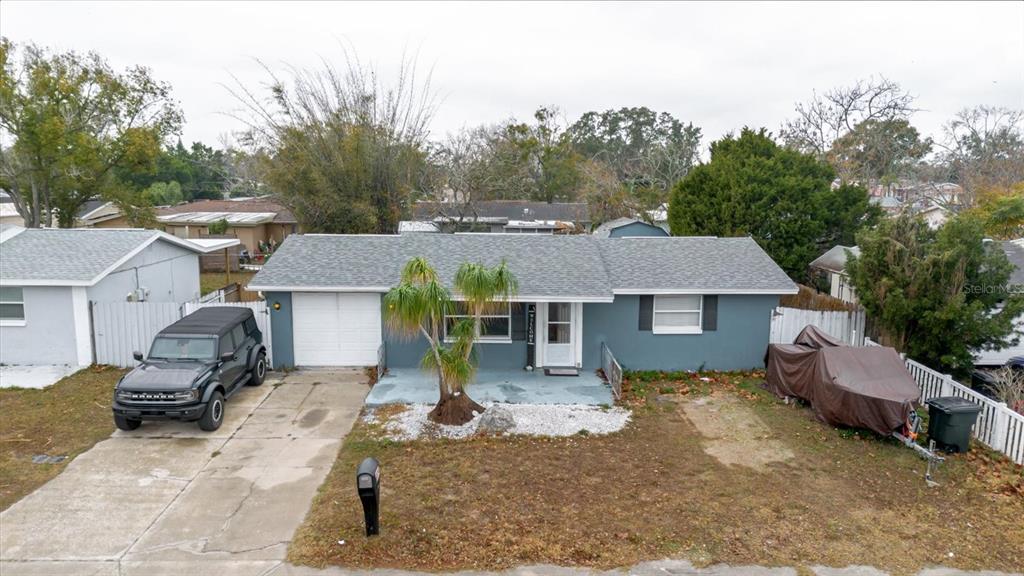 A single-story house with a blue exterior, a gray roof, and a front driveway — 9731 RAINBOW LANE, PORT RICHEY, FL