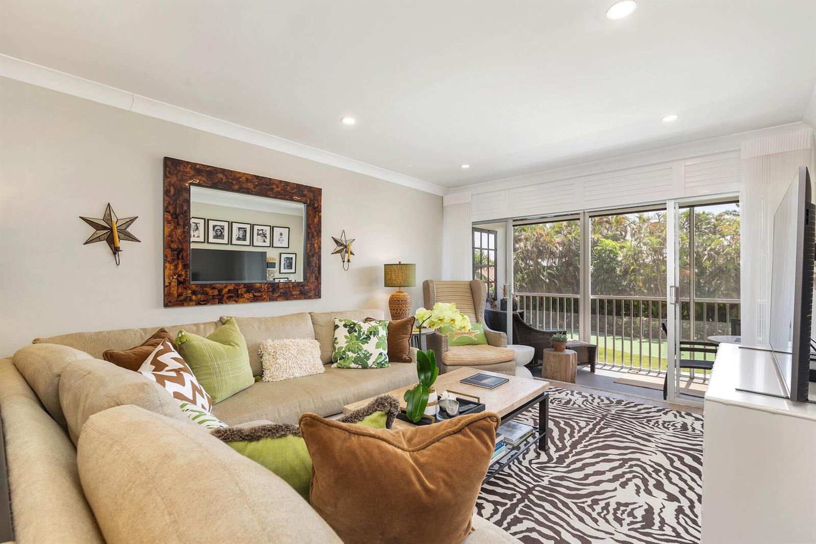 A living room features a beige sectional sofa, a zebra-print rug, and a balcony view — 1910 S Ocean Boulevard # 224, Delray Beach FL 33483, DELRAY BEACH, FL