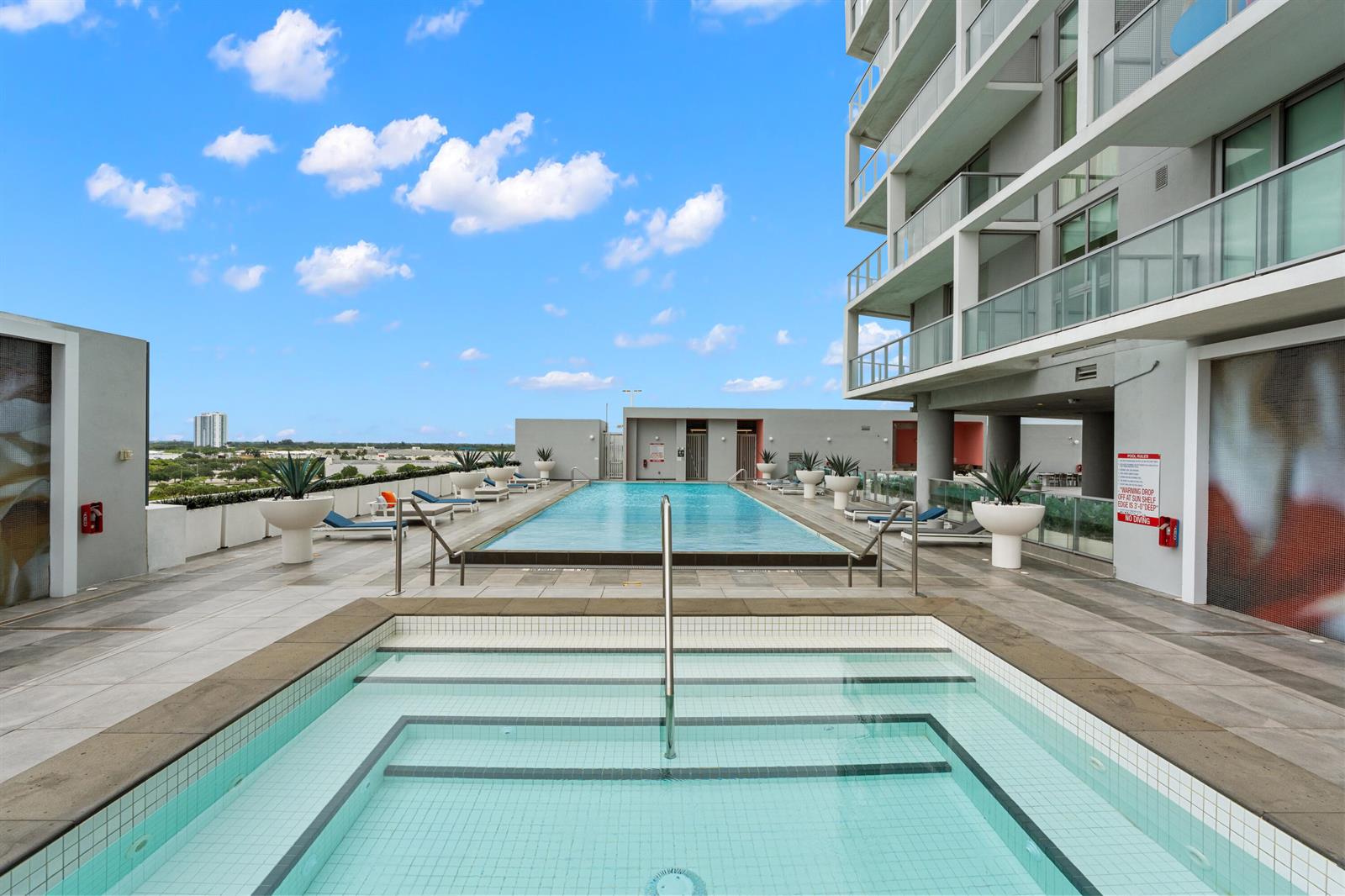 A rooftop swimming pool and hot tub are located on a terrace beside a building — 2000 Metropica Way # 214, Sunrise FL 33323, SUNRISE, FL