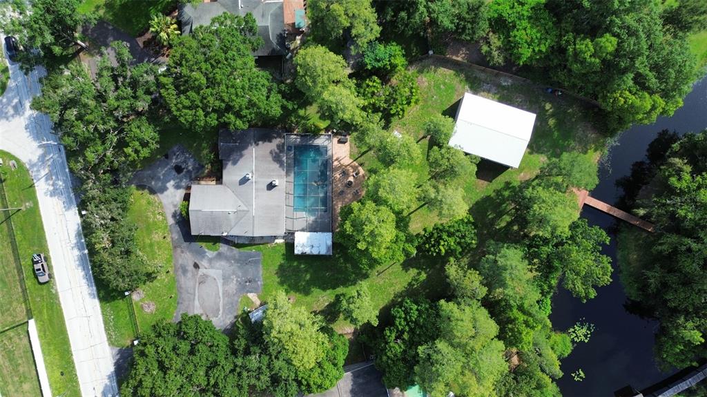 An aerial view shows a house with a pool, detached garage, and a backyard dock — 18306 CRAWLEY ROAD, ODESSA, FL