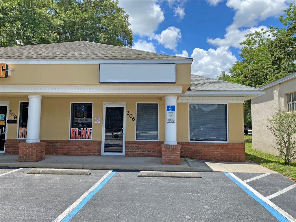 The exterior of a commercial building features a tan facade, brick accents, and a parking lot — 206 S US HIGHWAY 27/441, LADY LAKE, FL