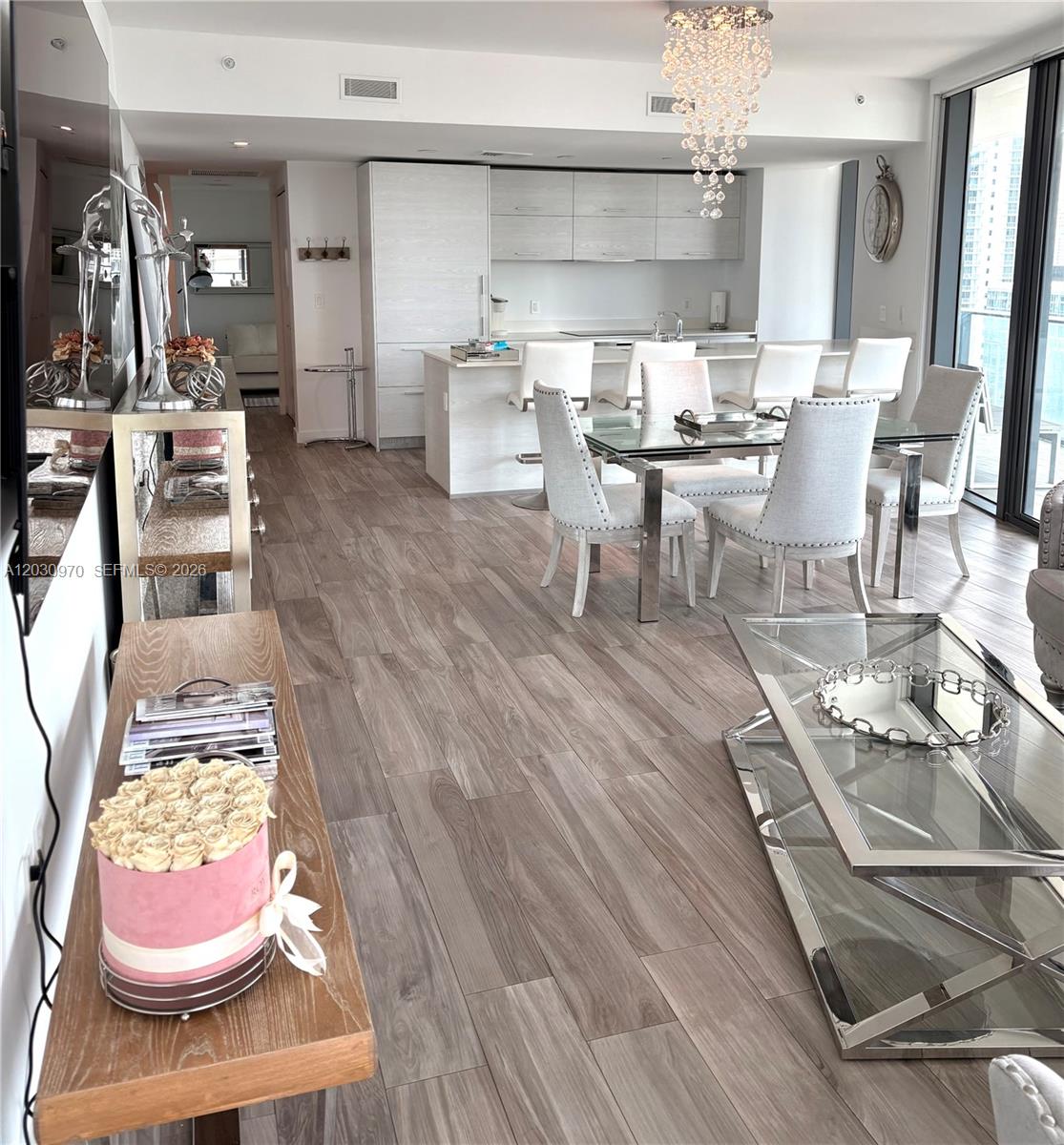 An open-concept living and dining area features light wood flooring and a modern kitchen — 1300 S Miami Ave # 2205, Miami FL 33130, MIAMI, FL