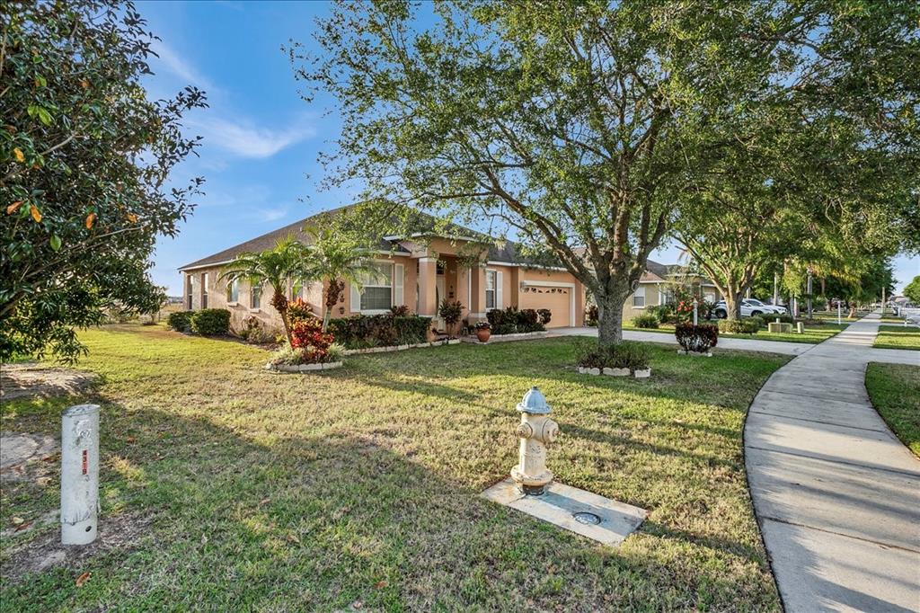 A single-story suburban house with a tan exterior, a front lawn, and a fire hydrant — 4319 DINNER LAKE BOULEVARD, LAKE WALES, FL
