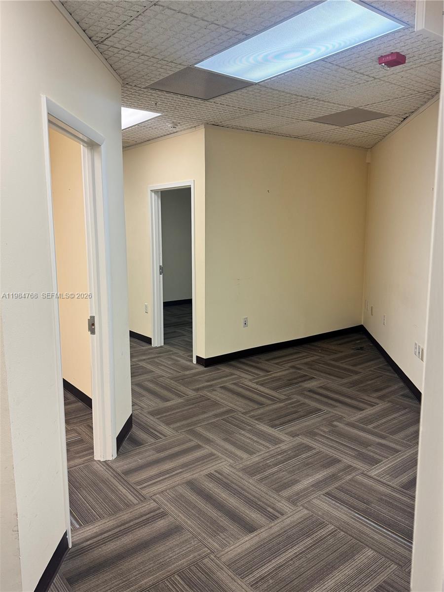 An office space features beige walls, a patterned carpeted floor, and a drop ceiling — 5959 Waterford District Dr # 101, Miami FL 33126, MIAMI, FL