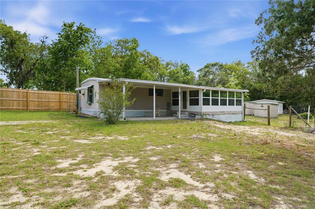 A single-story mobile home with a covered porch and screened-in area sits on a lot — 5494 S OLDFIELD AVENUE, HOMOSASSA, FL